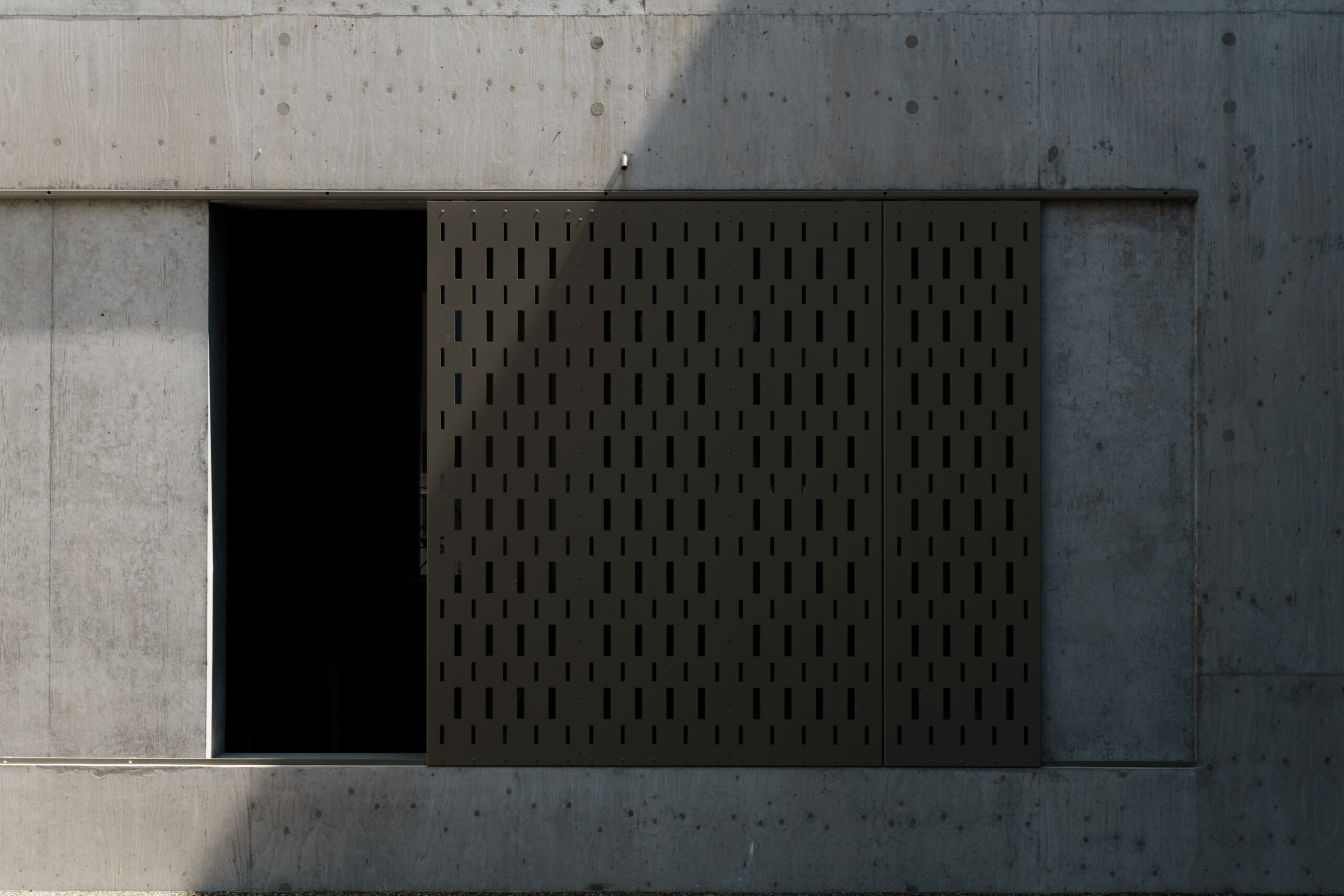 Eingangstür Detail - Perforiertes Metallgitter und Betonwand - Moderne Architekturdetails