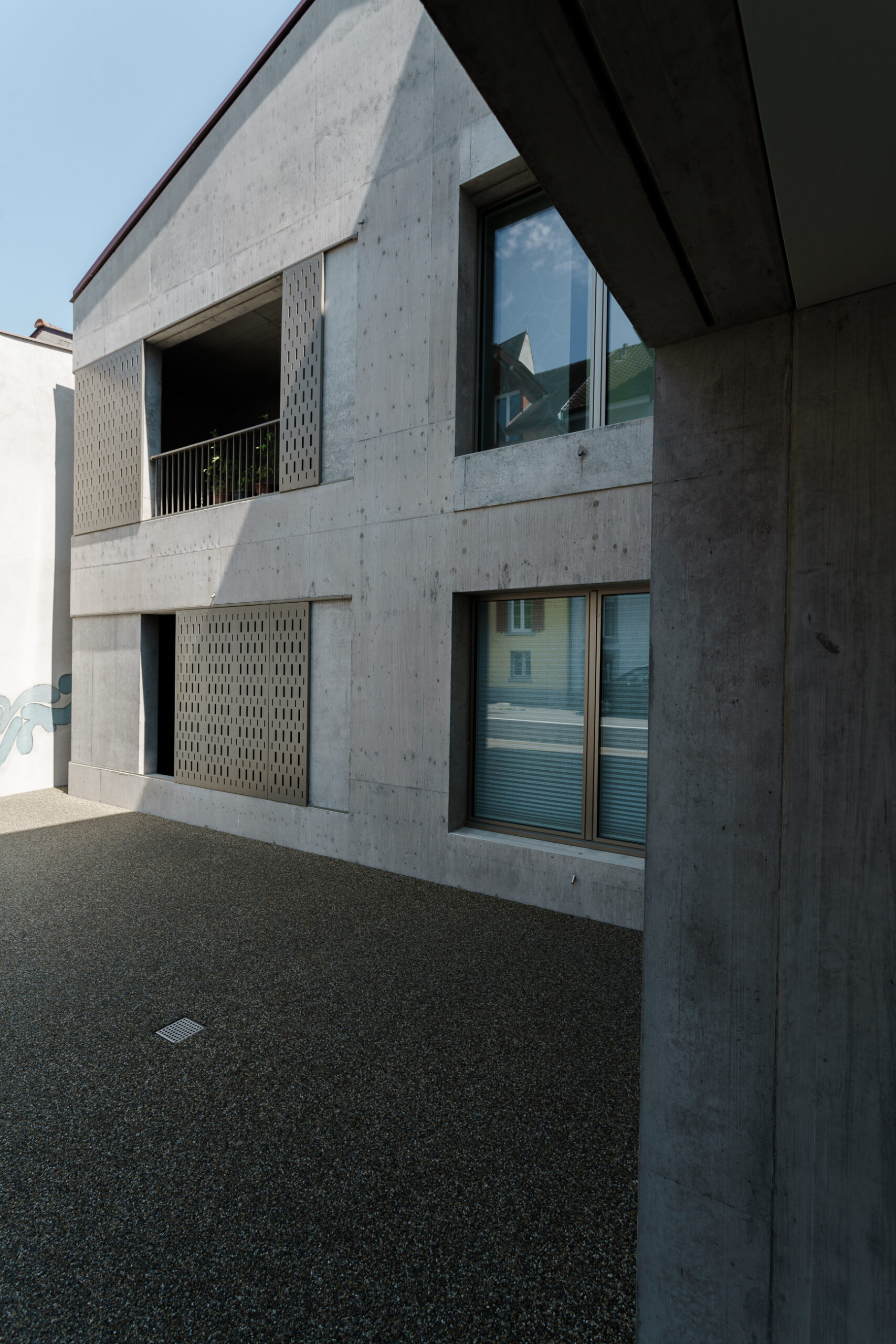 Gebäudeecke mit Fenster und Balkontür - Betonkonstruktion mit Metallgeländer - Architekturfotografie Klingnau